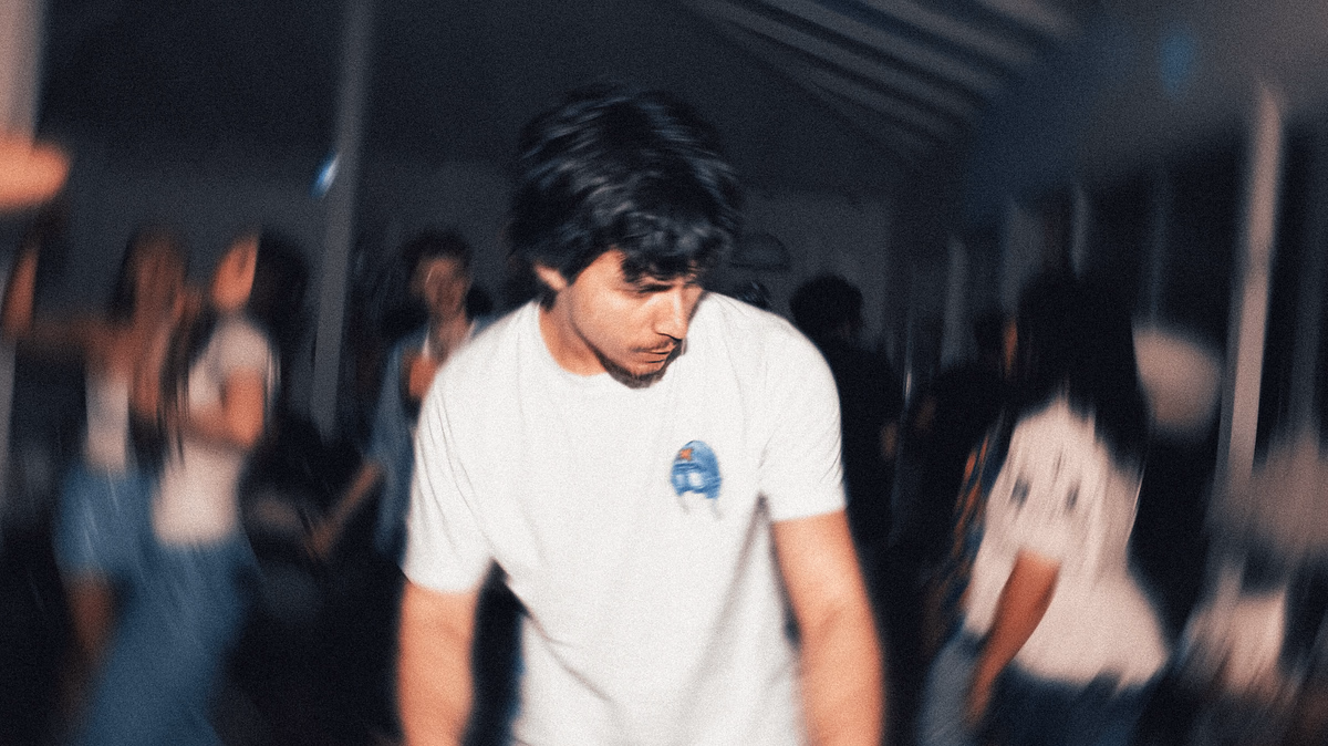 Bedir Ekim DJing, with a crowd blurred in motion behind him.